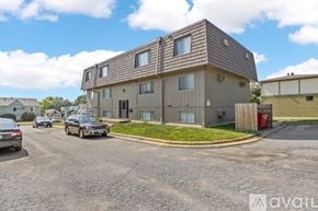Iowa City apartment for rent - A modern house with a brown roof and a parking lot in front.