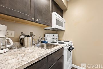 Iowa City apartment for rent - A kitchen with a white stove top oven and a white microwave above it.
