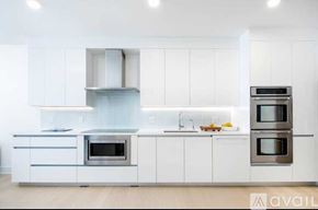 North Bergen condo for rent - A modern kitchen with white cabinets and stainless steel appliances.
