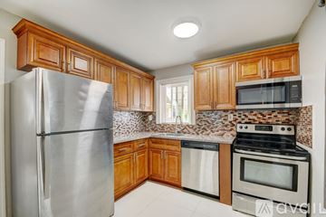 Lake Worth apartment for rent - A kitchen with wooden cabinets and a stainless steel refrigerator.