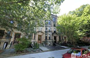 Brookline apartment for rent - A red car is parked on the street in front of a row of townhouses.