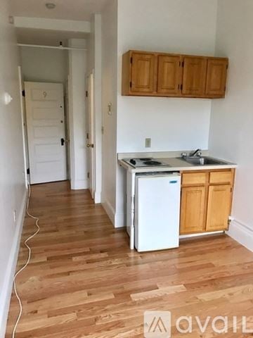 Brookline apartment for rent - A kitchen with wooden cabinets and a white fridge.