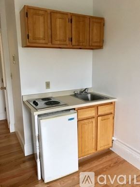 Brookline apartment for rent - A kitchen with wooden cabinets and a white fridge.