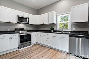 Hickory apartment for rent - A kitchen with white cabinets and a black countertop.