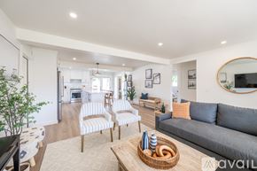 Oceanside house for rent - A living room with a grey couch, a coffee table, and a mirror on the wall.