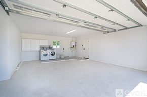 Oceanside house for rent - A spacious garage with a concrete floor and white walls.