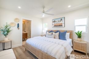 Oceanside house for rent - A bedroom with a large bed and a ceiling fan.