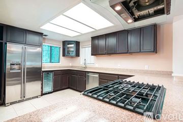 Somerset house for rent - A kitchen with a refrigerator, cabinets, and a stove top.