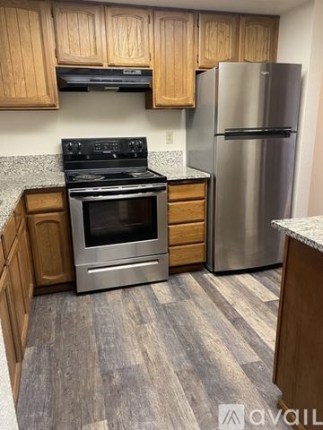 Salem apartment for rent - A kitchen with a stove, refrigerator, and wooden cabinets.