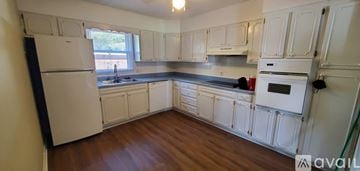 Flat Rock condo for rent - A kitchen with white cabinets and a black fridge.