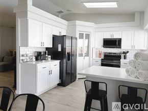 Lake Havasu City house for rent - A modern kitchen with white cabinets and black appliances.
