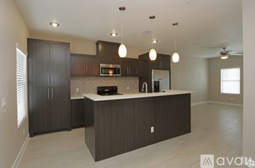 El Paso townhouse for rent - A modern kitchen with dark wood cabinets and a central island.