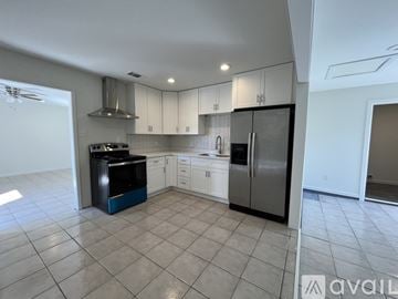 Harvey house for rent - A kitchen with white cabinets and a black dishwasher.