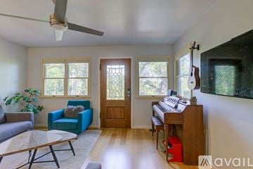 Austin house for rent - A living room with a blue chair and a wooden piano.