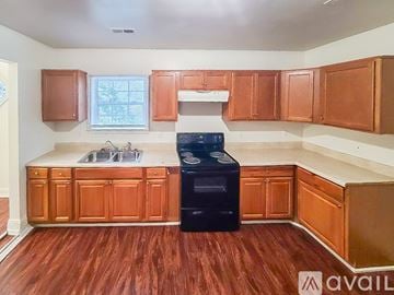 Petersburg house for rent - A kitchen with wooden cabinets and a black dishwasher.