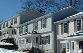 Worcester townhouse for rent - A row of houses with white siding and dark shutters.