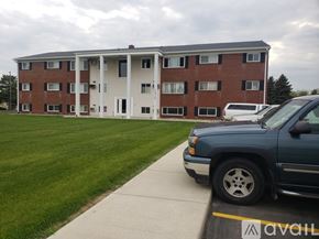 Saint Johns apartment for rent - A blue truck is parked in front of a multi-story building.