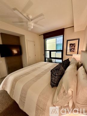 San Diego condo for rent - A bedroom with a bed, a ceiling fan, and a window.