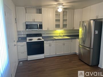 Cincinnati house for rent - A kitchen with white cabinets and a stainless steel refrigerator.