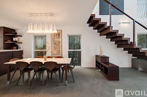 Los Angeles house for rent - A modern dining room with a wooden table and chairs.