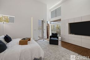 Los Angeles house for rent - A bedroom with a large bed and a television in the corner.