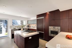 Los Angeles house for rent - A modern kitchen with dark wood cabinets and a white island.