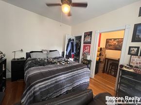 Boston apartment for rent - A bedroom with a bed, a ceiling fan, and a chair.