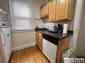 Boston apartment for rent - A kitchen with wooden cabinets and black countertops.