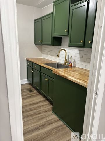 Columbia apartment for rent - A kitchen with green cabinets and a wooden counter.