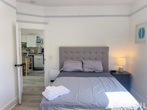 San Diego apartment for rent - A bedroom with a large bed and a lamp on the nightstand.