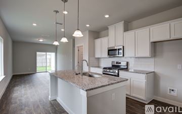 San Antonio house for rent - A kitchen with a granite countertop and white cabinets.