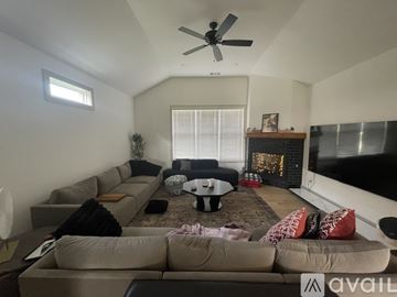 Bentonville house for rent - A living room with a large couch and a fireplace.