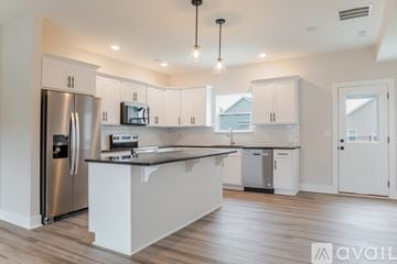 Jeffersonville house for rent - A modern kitchen with a stainless steel refrigerator and white cabinets.