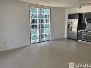 Miami condo for rent - A spacious kitchen with a view of a high-rise building outside the window.
