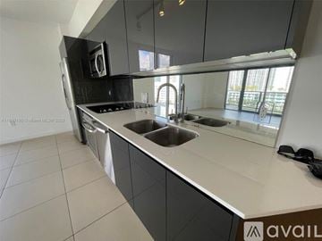 Miami condo for rent - A modern kitchen with a stainless steel dishwasher and a double sink.