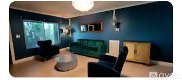 Dania Beach house for rent - A living room with a green couch and a grey ottoman.