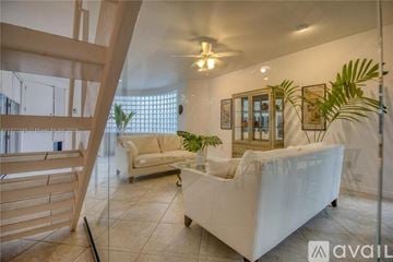 Miami house for rent - A living room with a white couch and a ceiling fan.