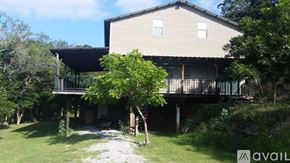 Spicewood house for rent - A house with a balcony and a tree in front of it.