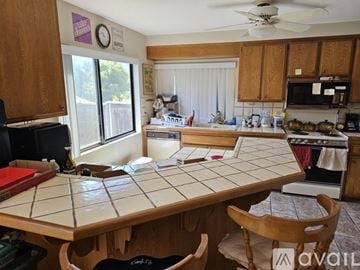 San Diego house for rent - A kitchen with a table and chairs in the foreground and a microwave and oven in the background.