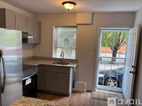Philadelphia house for rent - A kitchen with a refrigerator, sink, and cabinets.