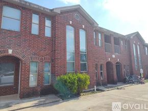 Pharr apartment for rent - A red brick building with a balcony on the second floor.