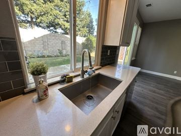 Lodi house for rent - A kitchen with a sink and a window overlooking a backyard.