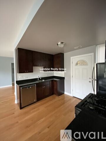 Chicago apartment for rent - A kitchen with wooden cabinets and a black stove top oven.
