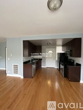 Chicago apartment for rent - A kitchen with wooden floors and a logo that reads "avail".