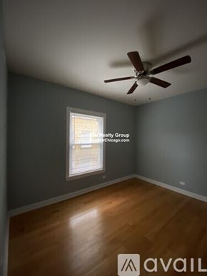 Chicago apartment for rent - A room with a fan and a window showing a view of a building.