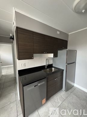 Schiller Park apartment for rent - A kitchen with a sink, refrigerator, and cabinets.