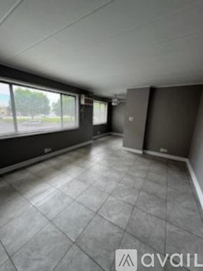 Schiller Park apartment for rent - A room with grey tiled flooring and large windows.