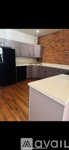 Wilmington apartment for rent - A kitchen with a black fridge and wooden floors.