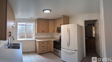 Enoch house for rent - A kitchen with white appliances and wooden cabinets.