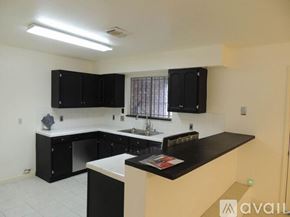 Houston house for rent - A kitchen with black cabinets and a white countertop.